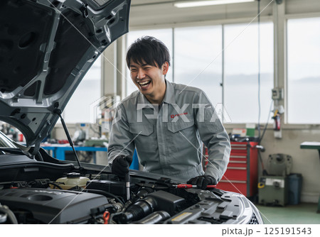工場で楽しそうに作業する整備士 125191543