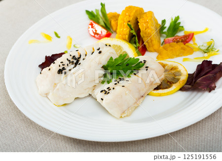 Codfish steamed and served with boiled corn, herbs and lemon Codfish steamed and served with boiled corn, herbs and lemon 125191556