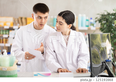 Two pharmacists employee using computer 125191668