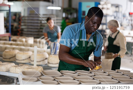Man potter polishing new crafted plates Man potter polishing new crafted plates 125191759