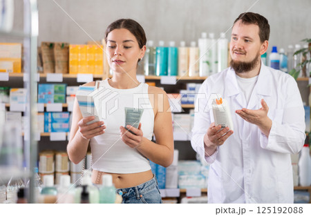 Woman choosing cream with help from pharmacist Woman choosing cream with help from pharmacist 125192088