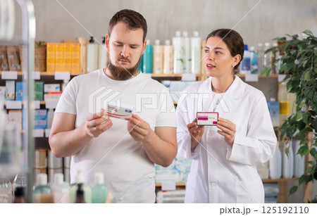 Man choosing paracetamol with help from pharmacist 125192110