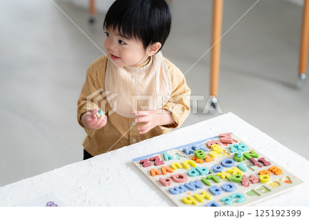 アルファベットパズルをする1歳の男の子 125192399