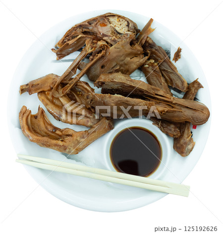 Portion of fried boiled parts of duck carcass is laid out on plate - paws, wings, head 125192626