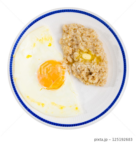 Breakfast with scrambled eggs and oatmeal with butter closeup Breakfast with scrambled eggs and oatmeal with butter closeup 125192683