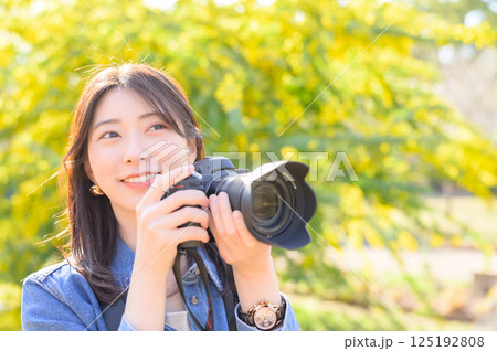 花を撮影する若い女性カメラマン 125192808