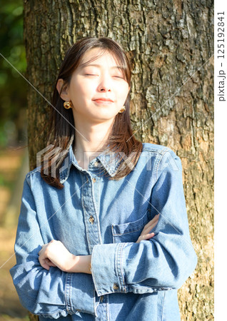 日差しを浴びて微笑む若い女性 日差しを浴びて微笑む若い女性 125192841