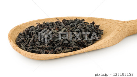 Dry black tea leaves in wooden spoon isolated on white background 125193158