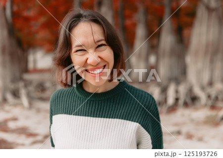 Portrait of smiling woman in autumn park. Stylish woman with happy emotions 125193726