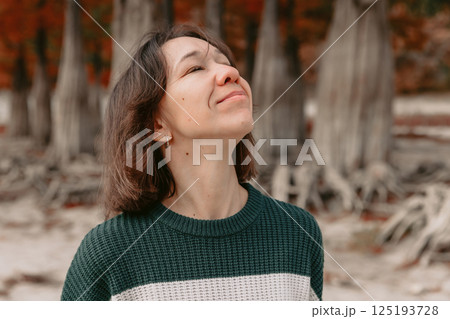 Portrait of enjoying woman in autumnal park. Stylish woman with happy emotions Portrait of enjoying woman in autumnal park. Stylish woman with happy emotions 125193728