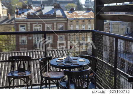 Terrace with table and chairs against the backdrop of a European city Terrace with table and chairs against the backdrop of a European city 125193756
