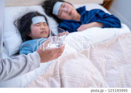 体調不良の家族を看病する男性 125193995