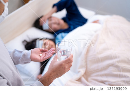 体調不良の家族を看病する男性 体調不良の家族を看病する男性 125193999