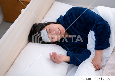 体調不良で寝込む女性 125194001