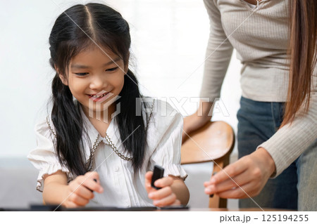Child Development and Family Interaction. A joyful child engages with her mother during a game, fostering happiness. Child Development and Family Interaction. A joyful child engages with her mother during a game, fostering happiness. 125194255
