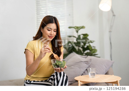 Healthy Breakfast and Nutrition. A woman enjoying a wholesome salad as part of her morning meal for a healthy start to the day. Healthy Breakfast and Nutrition. A woman enjoying a wholesome salad as part of her morning meal for a healthy start to the day. 125194286