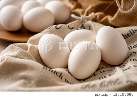 布の上にまとめて置かれた卵 125195096