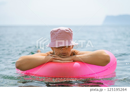 Freelance close up woman hands writing on computer. Well looking middle aged woman typing on laptop keyboard outdoors with beautiful sea view. 125195264