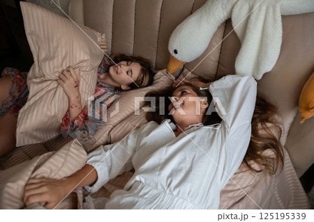 Mother Daughter Bedtime Relaxation Indoor Night bonding comfort bedtime story playfully share stuffed swan toy. Mother Daughter Bedtime Relaxation Indoor Night bonding comfort bedtime story playfully share stuffed swan toy. 125195339