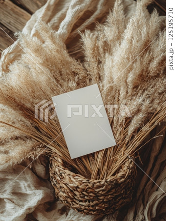 Blank A5 card on dried pampas grass in rustic basket Blank A5 card on dried pampas grass in rustic basket 125195710