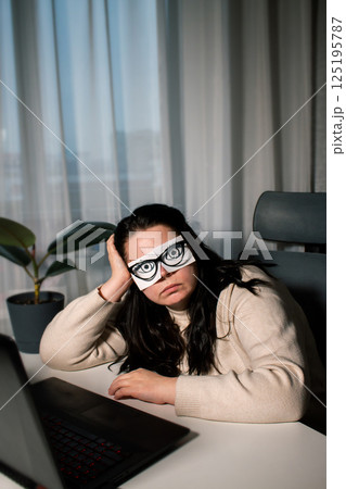 Tired Caucasian woman freelancer feeling stressed from work problems. Irritation burnout. Painted eyes on adhesive notes glued to face. Not having enough sleep Tired Caucasian woman freelancer feeling stressed from work problems. Irritation burnout. Painted eyes on adhesive notes glued to face. Not having enough sleep 125195787
