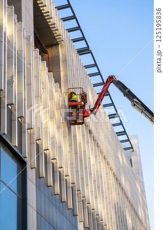 Construction crews and installers of high-rise buildings install fittings or lay electrical wiring 125195836