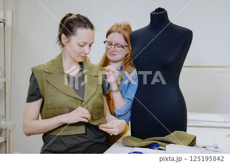 Atelier sewing workshop. female seamstress, fashion designer, takes measurements . 125195842