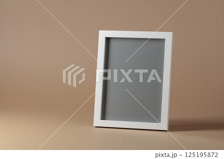 Empty picture frame on beige background. 125195872