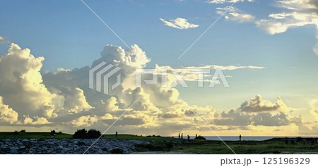 「芝生広がる海辺と入道雲、夏の夕暮れ散歩」 125196329