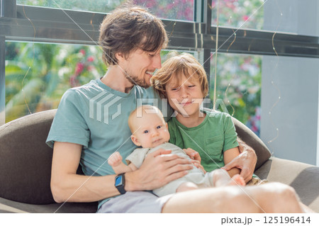 Father, son, and newborn baby sitting on the couch, joyfully celebrating the newest addition to their family. Parenthood, bonding, and family love concept Father, son, and newborn baby sitting on the couch, joyfully celebrating the newest addition to their family. Parenthood, bonding, and family love concept 125196414