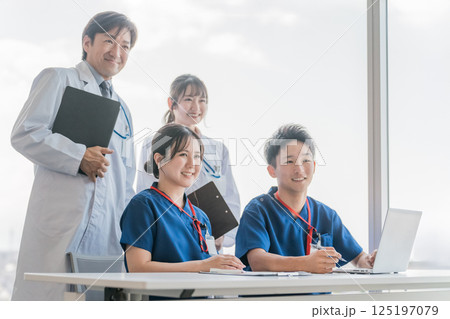 医局で打ち合わせ・ミーティングする男女の医師・医者・看護師・医療従事者・技師 医局で打ち合わせ・ミーティングする男女の医師・医者・看護師・医療従事者・技師 125197079