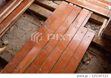 Old wooden planks. Replacement of the wooden floor in the living room, repair work Old wooden planks. Replacement of the wooden floor in the living room, repair work 125197123