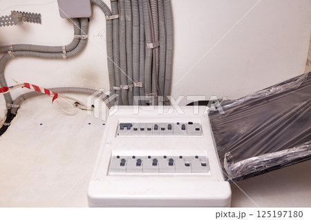 Electrical wires in a protective corrugated pipe on the ceiling and a modular housing on the wall Electrical wires in a protective corrugated pipe on the ceiling and a modular housing on the wall 125197180