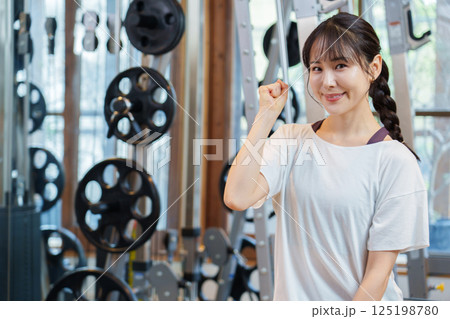 スポーツジムでガッツポーズをする女性 125198780