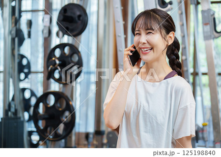 スポーツジムで電話をかける女性 スポーツジムで電話をかける女性 125198840
