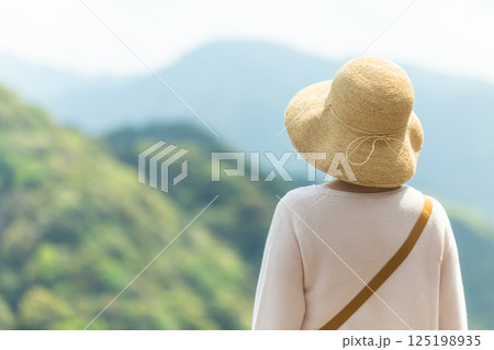 展望台から山並みを眺めるミドル女性 125198935