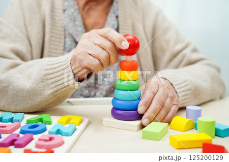 Asian elderly woman playing game. 125200129