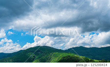 夏の青空に流れるたくさんの白い雲と、新緑の山並み 夏の青空に流れるたくさんの白い雲と、新緑の山並み 125200414