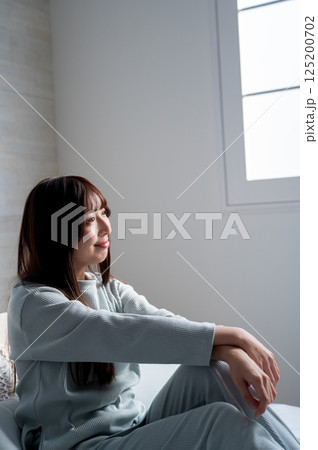 ベッドでリラックスする若い女性 125200702