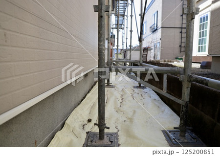 戸建住宅工事で養生シートを敷いた上に設置したくさび足場 125200851