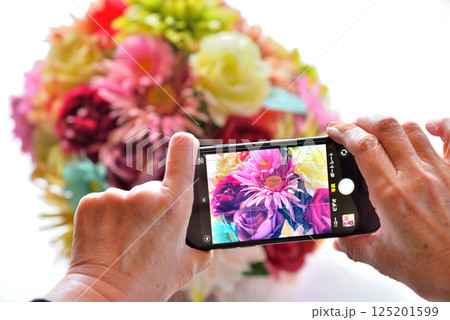 携帯電話で花の写真を撮るシニア 携帯電話で花の写真を撮るシニア 125201599