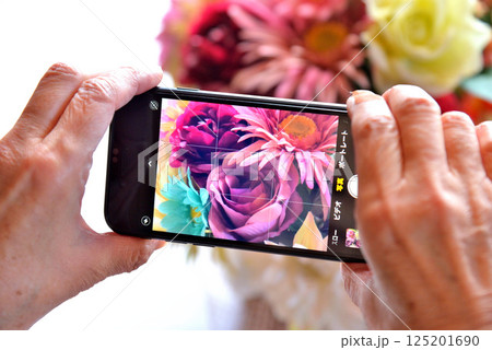 携帯電話で花の写真を撮るシニア 携帯電話で花の写真を撮るシニア 125201690