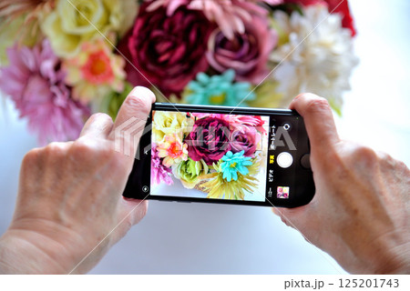 携帯電話で花の写真を撮るシニア 携帯電話で花の写真を撮るシニア 125201743