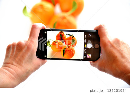 携帯電話で花の写真を撮るシニア 125201924