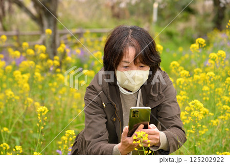 携帯電話で花の写真を撮るシニア 携帯電話で花の写真を撮るシニア 125202922