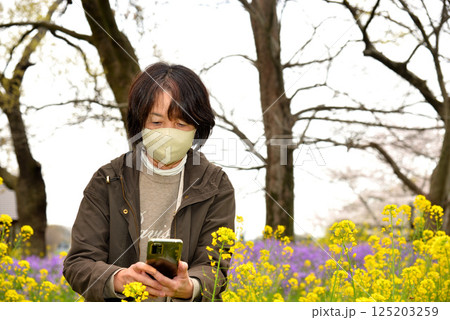 携帯電話で花の写真を撮るシニア 携帯電話で花の写真を撮るシニア 125203259