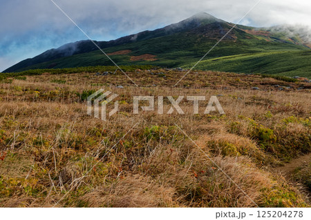 飯豊連峰・主稜線縦走路の草紅葉と雲流れる飯豊本山 125204278