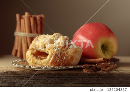 Viennese strudel with apple and cinnamon on old wooden table. 125204887