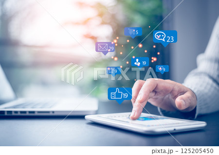 Social media and digital online concept. Businesswoman working with tablet in corporate office with notification icons of like, message, comment and star above smartphone screen. Social media. 125205450