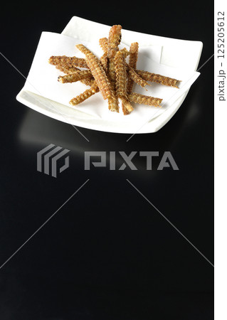 鰻の骨の煎餅を黒背景で撮影 125205612